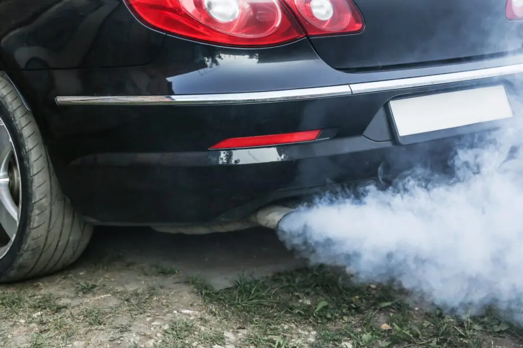 White smoke from the exhaust pipe of a car due to increased oil consumption in the engine