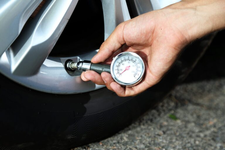 Hand holding pressure gauge for car tyre pressure measurement