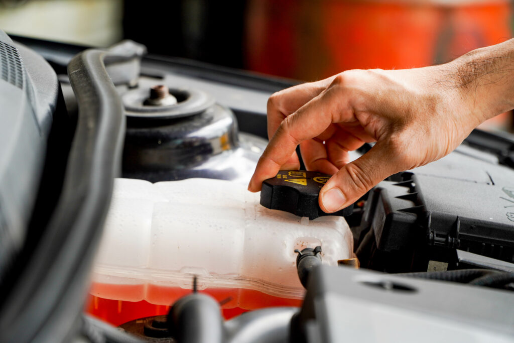 Close-up of hand working under the hood of car.