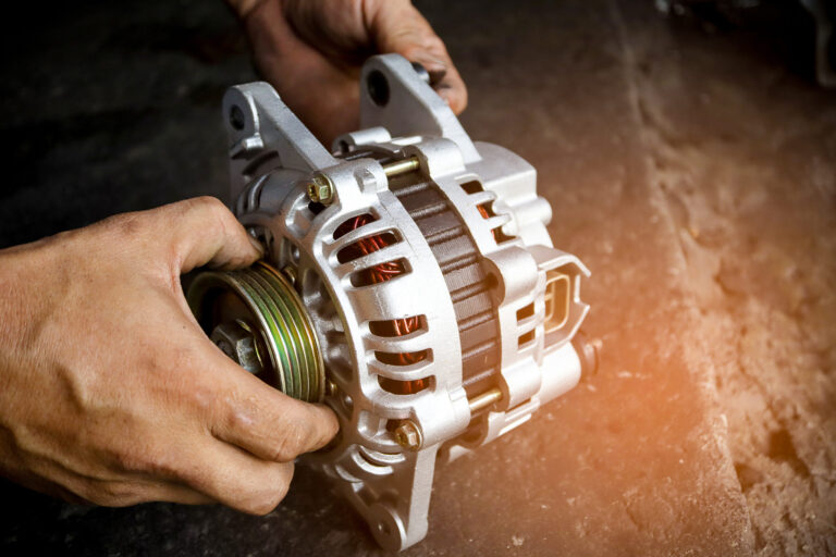 Close-up of hands holding alternator.