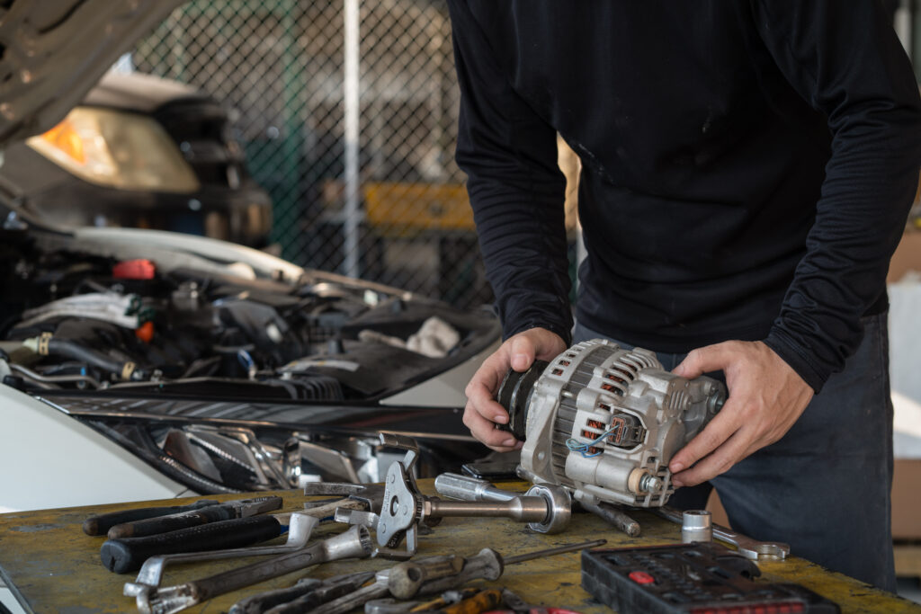 Man repairing alternator. 