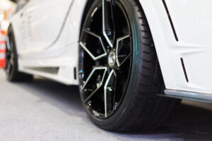 Closeup photo of a tire on a white car in a show room