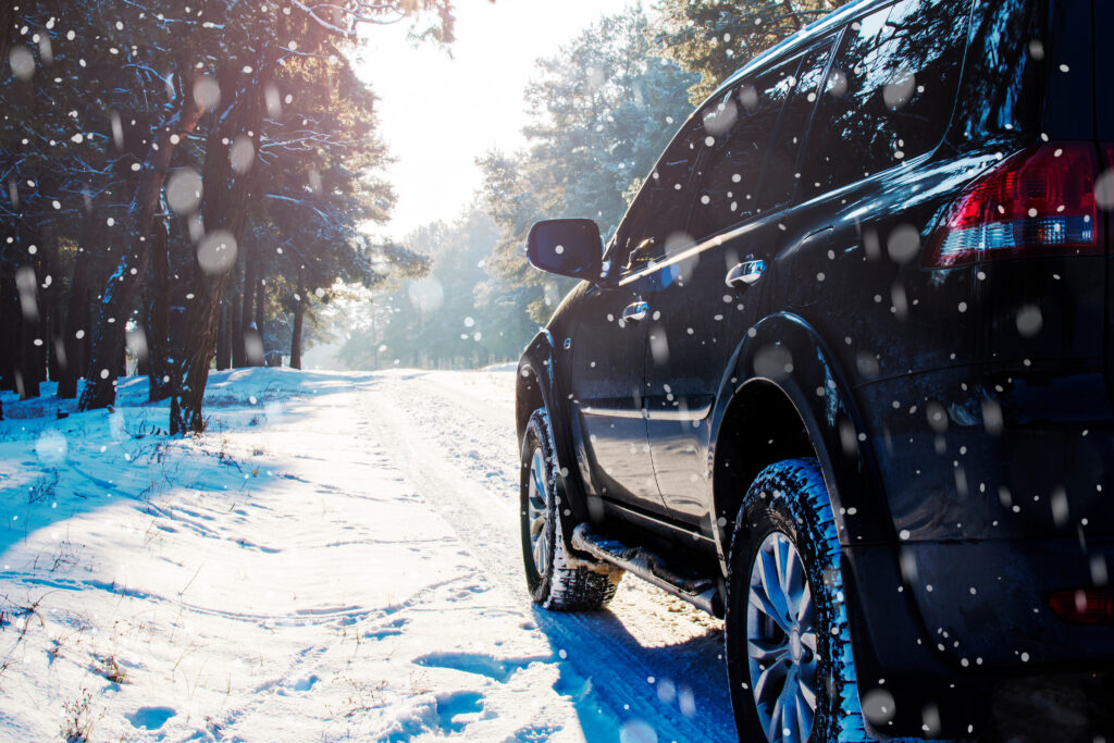 SUV driving on snowy road. 