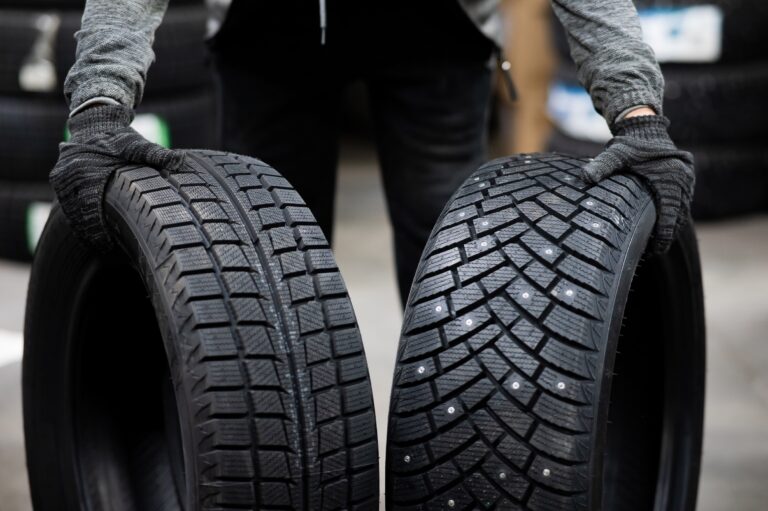 Mechanic keeps new summer and winter car tires in the garage. Comparison of wheels for different seasons