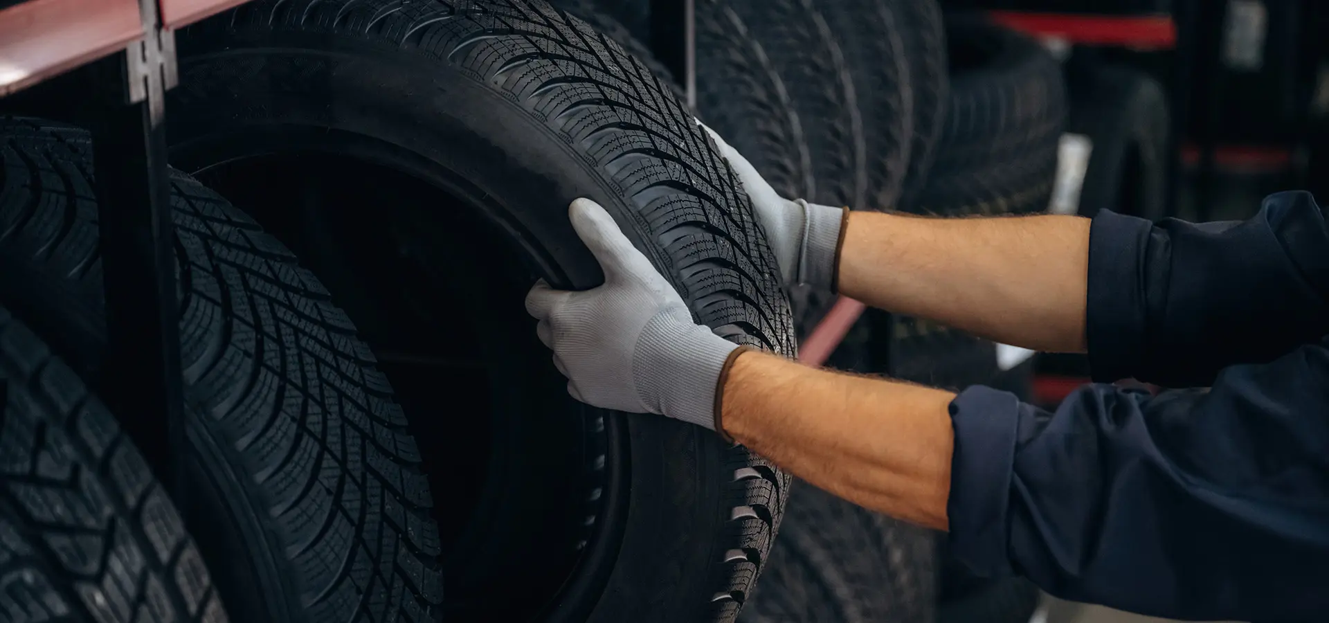 A Telle Tire technician pulling a new tire out of the rack at the shop.
