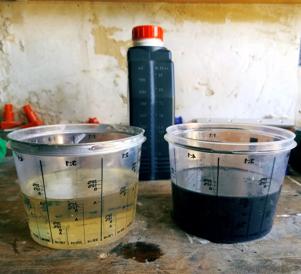 Two measuring glasses with clean and used engine oil standing on the table against the background of the canister