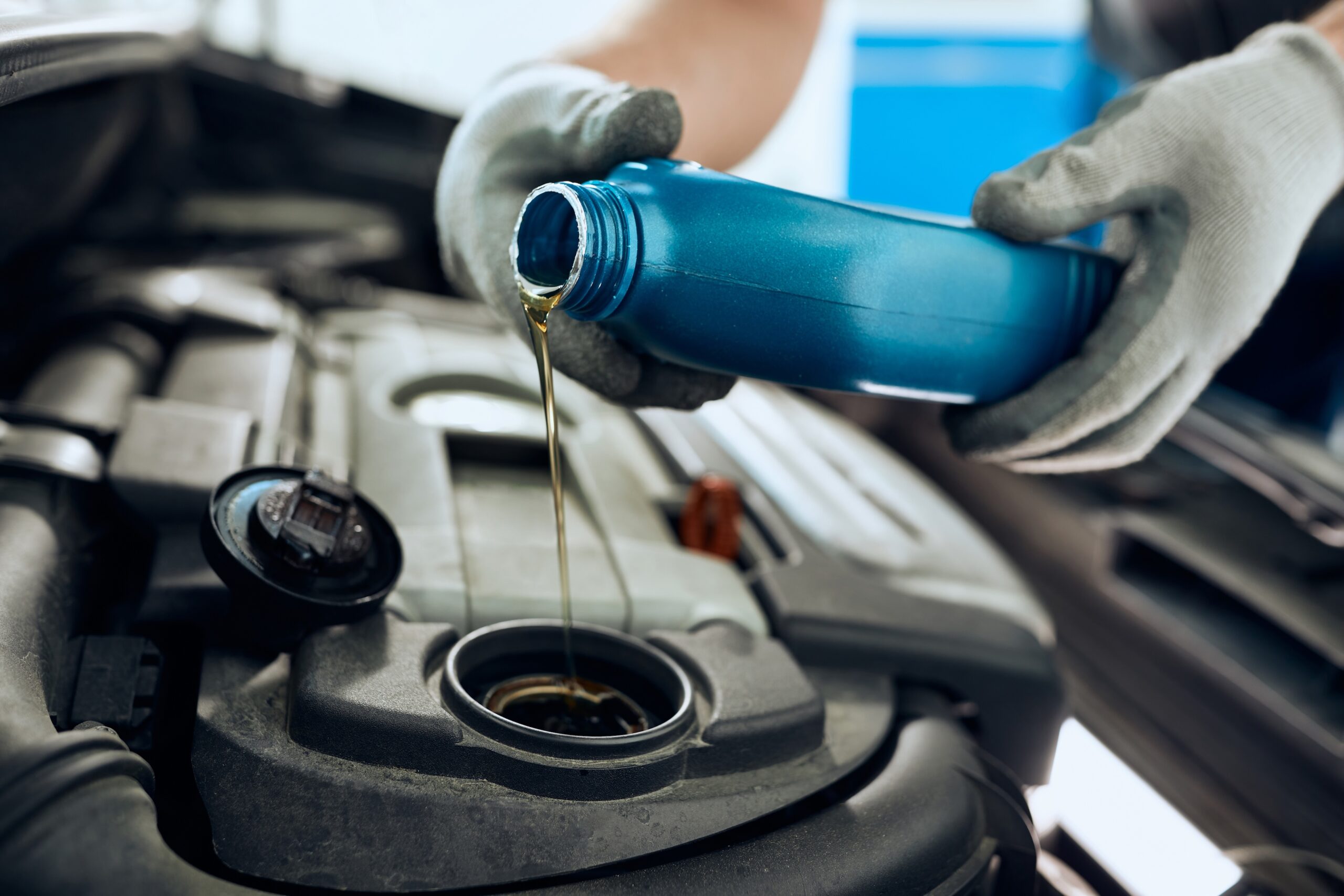 Close- up of mechanic pouring new motor oil while doing an oil change at Telle Tire.