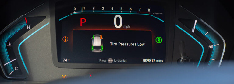 Panorama view tire pressure low indicator display on instrument panel of modern car minivan in Parking mode, tire pressure monitoring system TPMS indicates lights on driver information interface.