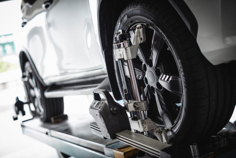 Car wheel alignment services in progress in a Telle Tire shop.