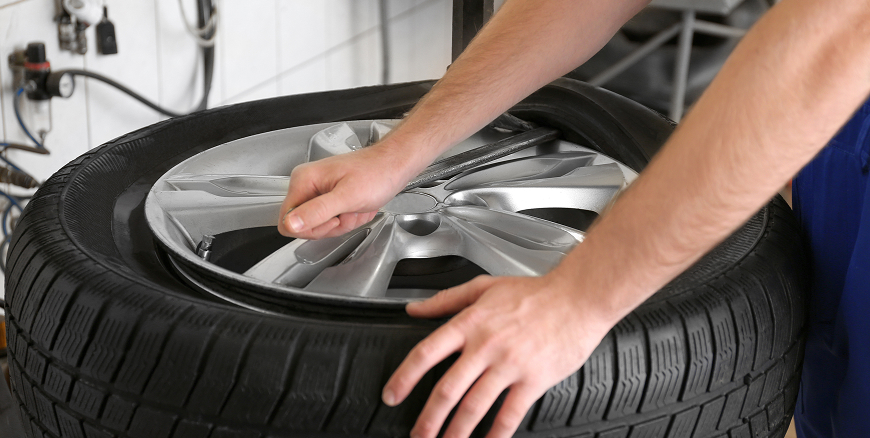 Telle Tire technician prying a tire off the wheel rim for a replacement.